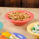 A bowl of food on a table with a GET Rio Orange melamine bowl.