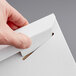 A hand opening a white Lavex Stayflats rigid mailer box.