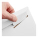 A white tab-locking rigid mailer being closed by hand.