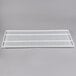 A white wire shelf on a gray background.