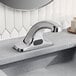 A Zurn Elkay silver electronic faucet with a black sensor on a counter.