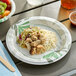 A Dixie Ultra Pathways paper plate with food and a drink on a table.