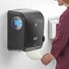 A woman in a lab coat using a Pacific Blue Ultra mechanical paper towel dispenser.