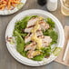 A Dixie Ultra Pathways paper plate with pasta and salad on a table.