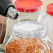 A close-up of a 2" perforated shrink band on a jar.