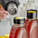 A close-up of a black perforated shrink band on a bottle.