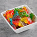 A bowl of Vidal Gummy Dinosaurs on a white background.