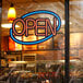 A Choice LED neon sign that says open with a blue oval and red lettering.