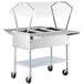 A ServIt stainless steel electric steam table on wheels with a clear cover.