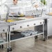 A man using a ServIt electric steam table to cook food.