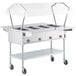 A ServIt open well electric steam table with clear sneeze guards on wheels.