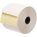 A roll of white paper with a yellow label and black circle.