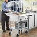 A man standing next to a ServIt electric steam table with food.