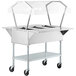 A stainless steel ServIt hot food cart with a clear cover on a table.