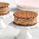 A salted caramel ice cream sandwich on a white stand.