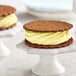 a cookie with a vanilla ice cream sandwich on a white stand