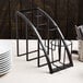 A black metal Cal-Mil vertical flatware display holding utensils on a table.