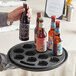 A person holding a Franmara non-skid tray with beer bottles.