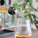 A Franmara black auto-close wine pourer pouring wine into a glass.