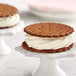 A close up of a cookie sandwich with white frosting on top.