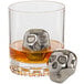 A glass of whiskey with a Franmara stainless steel reusable skull-shaped ice ball in it.