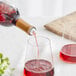 a bottle pouring red liquid into a glass