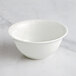 A RAK Porcelain ivory bowl with wavy lines on a marble surface.