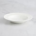 A RAK Porcelain ivory deep plate with a pattern on a marble surface.