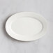 A RAK Porcelain ivory oval platter with wavy lines on a marble surface.