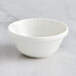 A close-up of a RAK Porcelain ivory bowl with wavy lines on it.