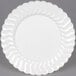 A close-up of a Fineline Flairware white plastic plate with wavy edges.