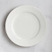 A RAK Porcelain ivory embossed porcelain plate with wide rim on a marble surface.
