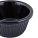 A black fluted melamine ramekin with a white background.