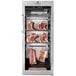 A stainless steel meat rack with meat dry aging in a DRY AGER meat curing cabinet.