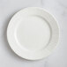 A RAK Porcelain ivory flat plate with wavy lines on the rim.