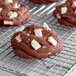 Chocolate chip cookies with Barry Callebaut white chocolate chunks cooling on a rack.