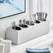 A white flatware organizer with stainless steel silverware in it.