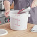 a hand holding a white container