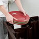 A person using a Cambro dark brown dish caddy to hold a stack of plates.