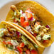 A plate of tacos with Upton's Naturals Banana Blossom on a table.