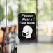 A Tablecraft "Please Wear a Face Mask" sign on a door.