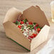 A EcoChoice #8 Kraft Take-Out box with a salad inside on a table.