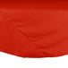 An orange Intedge round poly/cotton table cover on a table.