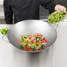 A chef using a Town hand hammered Cantonese wok to cook vegetables.