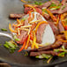 Fresh ginger root in a pan with steak and vegetables.