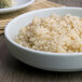 A bowl of rice with black pepper in a Thunder Group Blue Jade melamine bowl.