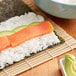 A sushi roll with rice and salmon.