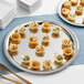 An American Metalcraft stainless steel serving tray with appetizers on it.
