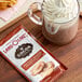 A glass mug of Land O Lakes Cocoa Classics Chocolate Snickerdoodle hot chocolate with whipped cream on top.