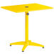 A yellow Lancaster Table & Seating dining table with a metal stand and umbrella hole.